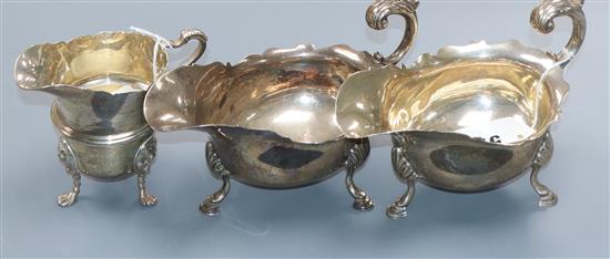 A matched pair of silver cream boats with shaped rims and C-scroll handles, London 1899/1900, 16oz and a helmet-shaped cream jug